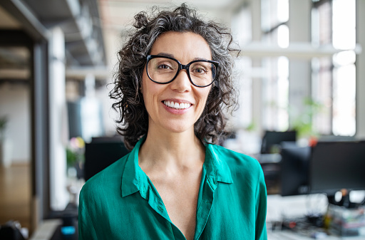 A woman wearing glasses and a green shirt smiling