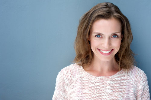 Smiling woman in front of blue background