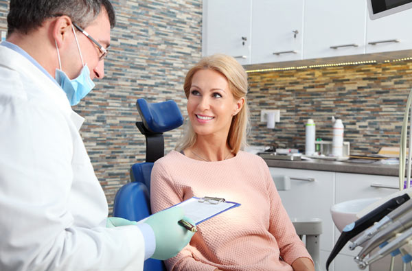 A woman talking to dentist during oral cancer screening at Myers Park Dental Partners in Charlotte, NC