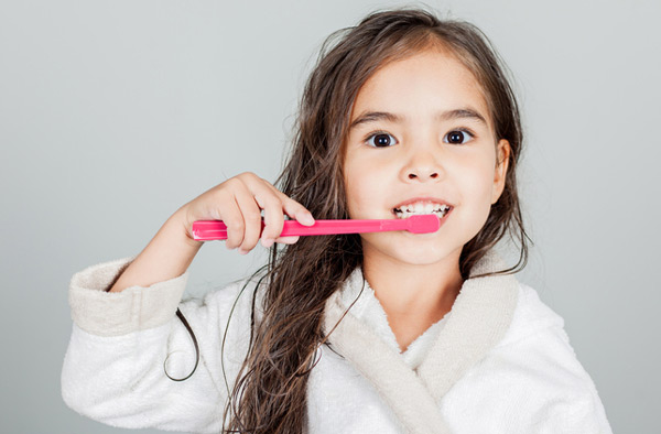 Young girl brushing her teeth after appointment at Myers Park Dental Partners in Charlotte, NC